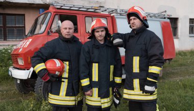 Bir grup itfaiyeci iyi yapılmış bir kurtarma operasyonundan sonra kendinden emin duruyor. İtfaiyeciler acil servise hazır. Yüksek kalite fotoğraf