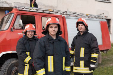 Bir grup itfaiyeci iyi yapılmış bir kurtarma operasyonundan sonra kendinden emin duruyor. İtfaiyeciler acil servise hazır. Yüksek kalite fotoğraf