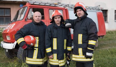 Bir grup itfaiyeci iyi yapılmış bir kurtarma operasyonundan sonra kendinden emin duruyor. İtfaiyeciler acil servise hazır. Yüksek kalite fotoğraf
