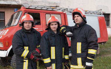 Bir grup itfaiyeci iyi yapılmış bir kurtarma operasyonundan sonra kendinden emin duruyor. İtfaiyeciler acil servise hazır. Yüksek kalite fotoğraf
