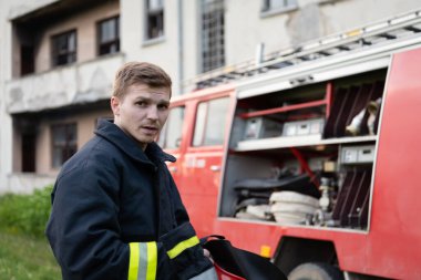 İtfaiye arabasının yanında depresif ve yorgun bir itfaiyeci. Yüksek kalite fotoğraf