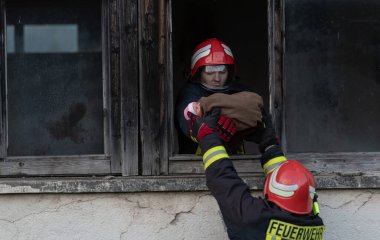 İtfaiyeci kahraman yangından sonra bebeğini yanan binadan dışarı taşıyor. İnsanları tehlikeli bir yerden kurtarmak. Takım çalışması Yüksek kalite fotoğraf