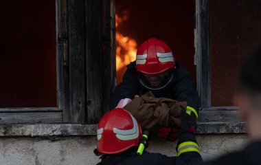 İtfaiyeci kahraman yangından sonra bebeğini yanan binadan dışarı taşıyor. İnsanları tehlikeli bir yerden kurtarmak. Takım çalışması Yüksek kalite fotoğraf