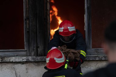 İtfaiyeci kahraman yangından sonra bebeğini yanan binadan dışarı taşıyor. İnsanları tehlikeli bir yerden kurtarmak. Takım çalışması Yüksek kalite fotoğraf