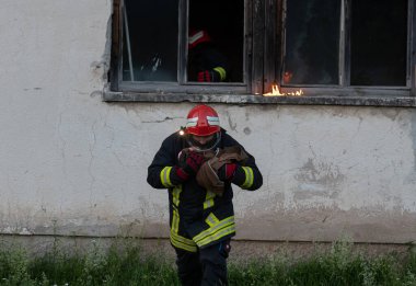 İtfaiyeci kahraman yangından sonra bebeğini yanan binadan dışarı taşıyor. İnsanları tehlikeli bir yerden kurtarmak. Takım çalışması Yüksek kalite fotoğraf