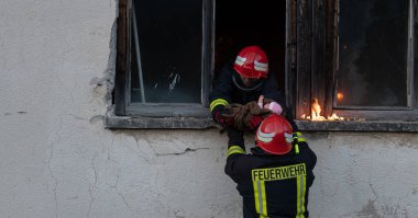 İtfaiyeci kahraman yangından sonra bebeğini yanan binadan dışarı taşıyor. İnsanları tehlikeli bir yerden kurtarmak. Takım çalışması Yüksek kalite fotoğraf