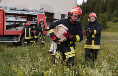 Bir grup itfaiyeci iyi yapılmış bir kurtarma operasyonundan sonra kendinden emin duruyor. İtfaiyeciler acil servise hazır. Yüksek kalite fotoğraf