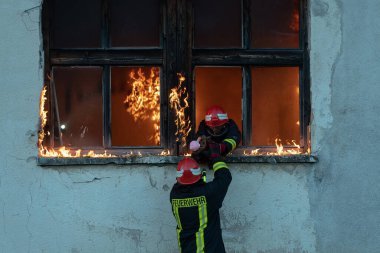İtfaiyeci kahraman yangından sonra bebeğini yanan binadan dışarı taşıyor. İnsanları tehlikeli bir yerden kurtarmak. Takım çalışması Yüksek kalite fotoğraf
