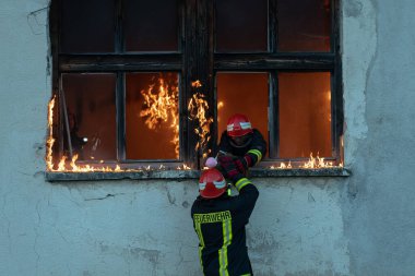 İtfaiyeci kahraman yangından sonra bebeğini yanan binadan dışarı taşıyor. İnsanları tehlikeli bir yerden kurtarmak. Takım çalışması Yüksek kalite fotoğraf