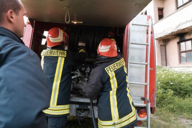 Bir grup itfaiyeci iyi yapılmış bir kurtarma operasyonundan sonra kendinden emin duruyor. İtfaiyeciler acil servise hazır. Yüksek kalite fotoğraf