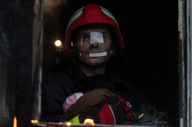 İtfaiyeci kahraman yangından sonra bebeğini yanan binadan dışarı taşıyor. İnsanları tehlikeli bir yerden kurtarmak. Takım çalışması Yüksek kalite fotoğraf