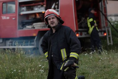 Depresyondaki yakışıklı bir itfaiyecinin portresi itfaiye aracının yanında. Yüksek kalite fotoğraf