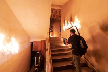 Cesur İtfaiyeci Yanan Binanın Merdivenlerinden İndi ve Kurtarılmış Kızı Kollarında Tuttu. Ateş açın. Sinematograf, profesyonel sinema kamerası ve üç eksenli dengeleyici ile çekim yapıyor. loş ışık