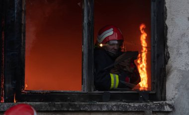 İtfaiyeci kahraman yangından sonra bebeğini yanan binadan dışarı taşıyor. İnsanları tehlikeli bir yerden kurtarmak. Takım çalışması Yüksek kalite fotoğraf