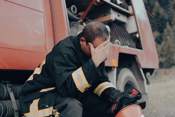 depressed and tired firefighter near fire truck. High quality photo