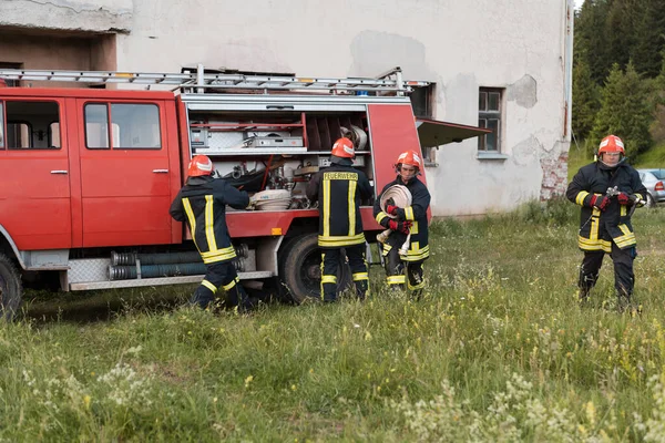 Group of fire fighters standing confident after a well done rescue operation. Firemen ready for emergency service. High quality photo