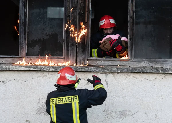 消防士のヒーロー火災事件から建物の領域を燃焼から赤ちゃんの女の子を運ぶ 危険な場所から人々を救う チームワーク高品質の写真 — ストック写真