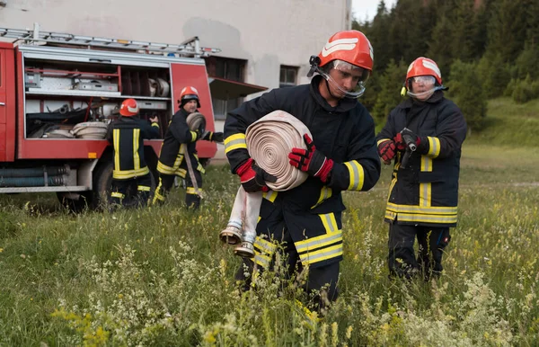 Bir grup itfaiyeci iyi yapılmış bir kurtarma operasyonundan sonra kendinden emin duruyor. İtfaiyeciler acil servise hazır. Yüksek kalite fotoğraf