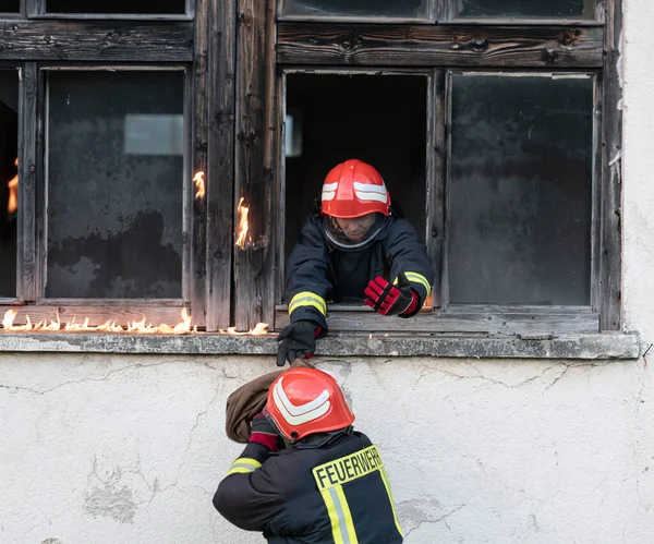 İtfaiyeci kahraman yangından sonra bebeğini yanan binadan dışarı taşıyor. İnsanları tehlikeli bir yerden kurtarmak. Takım çalışması Yüksek kalite fotoğraf