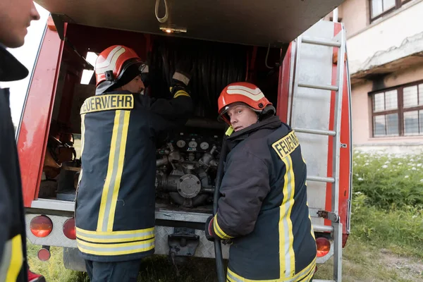 Group of fire fighters standing confident after a well done rescue operation. Firemen ready for emergency service. High quality photo