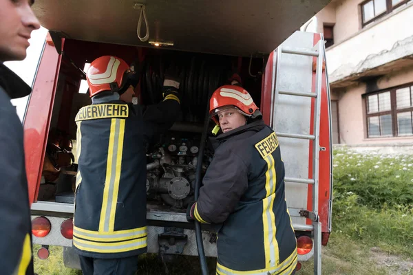 Group of fire fighters standing confident after a well done rescue operation. Firemen ready for emergency service. High quality photo