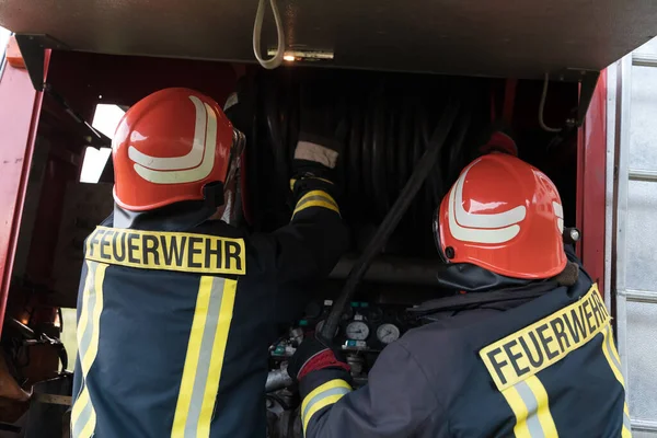 Group of fire fighters standing confident after a well done rescue operation. Firemen ready for emergency service. High quality photo