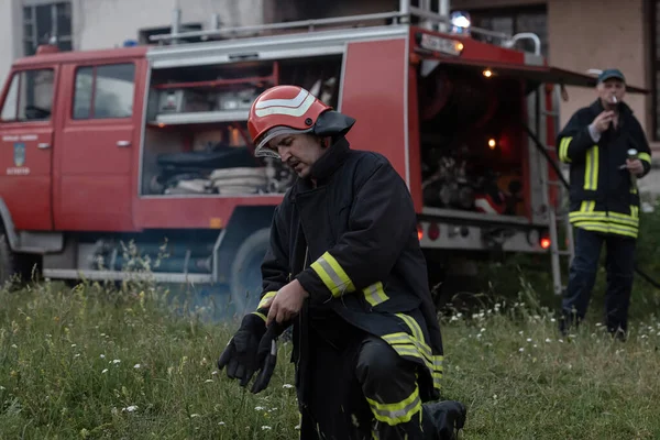 Depresyondaki yakışıklı bir itfaiyecinin portresi itfaiye aracının yanında. Yüksek kalite fotoğraf