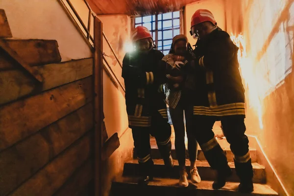 Γενναίος Πυροσβέστης Κατεβαίνει Τις Σκάλες Ενός Φλεγόμενου Κτιρίου Και Κρατάει — Φωτογραφία Αρχείου