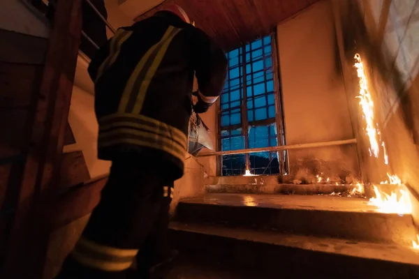 勇敢的消防员上楼去救人在燃烧的大楼里开火和火焰 低光喜是选择性焦距摄影 — 图库照片