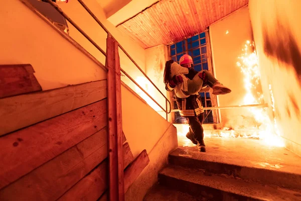 Хоробрий Пожежник Спускається Сходів Палаючої Будівлі Тримає Руках Врятовану Дівчину — стокове фото