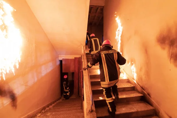 勇敢的消防员上楼去救人在燃烧的大楼里开火和火焰 低光喜是选择性焦距摄影 — 图库照片