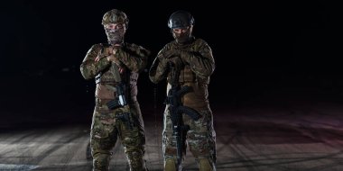 Ağır silahlı özel kuvvetler askerleri tam korumalı askeri teçhizatlarla otantik saldırı tüfekleriyle cesurca ve iyimser bir şekilde yürüyorlar. 