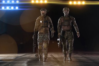 Ağır silahlı özel kuvvetler askerleri tam korumalı askeri teçhizatlarla otantik saldırı tüfekleriyle cesurca ve iyimser bir şekilde yürüyorlar. 