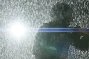 Silahlı asker saldırı tüfeği, plaka taşıyıcısı ve savaş kaskıyla yağmurlu bir gecede tehlikeli bir göreve çıkıyor. Yüksek kalite fotoğraf