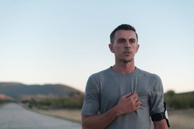 Çekici zinde bir adam gün batımında kırsal yolda hızla koşuyor, dışarıda koşuyor. Yüksek kalite fotoğraf