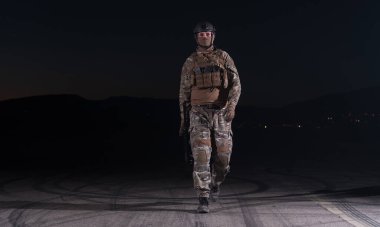 Silahlı asker saldırı tüfeği, plaka taşıyıcısı ve savaş kaskıyla yağmurlu bir gecede tehlikeli bir göreve çıkıyor. Yüksek kalite fotoğraf