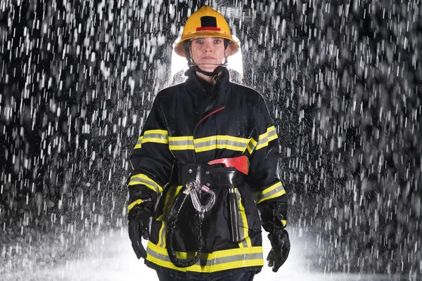 Portrait of a female firefighter standing and walking brave and optimistic. Heavy rain is good luck or firefighters for car rescue concept. High quality photo