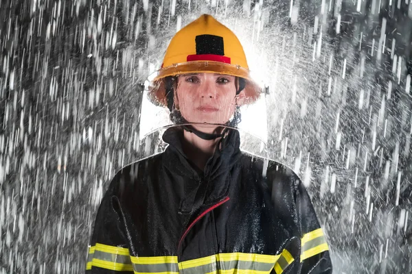 一个女消防员站在那里 勇敢而乐观地行走的形象 大雨是好运或消防员对汽车救援的概念 高质量的照片 — 图库照片