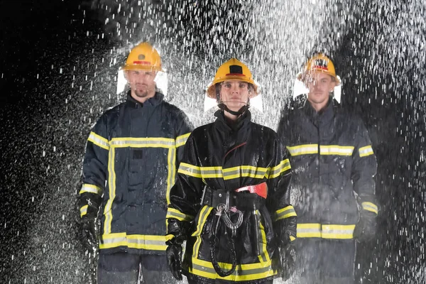 チームリーダーとして女性と勇敢で楽観的な歩行消防士のグループの肖像画 大雨は車の救助の概念のための幸運か消防士である 高品質の写真 — ストック写真
