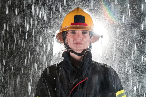 一个女消防员站在那里 勇敢而乐观地行走的形象 大雨是好运或消防员对汽车救援的概念 高质量的照片 — 图库照片