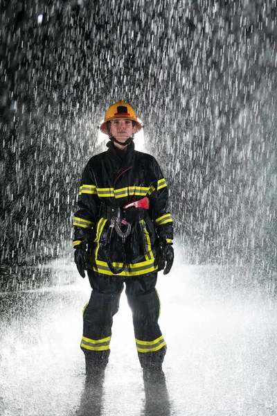 Portrait of a female firefighter standing and walking brave and optimistic. Heavy rain is good luck or firefighters for car rescue concept. High quality photo
