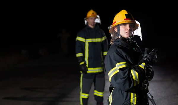 소방관들은 화재의 위험을 제거하기 호스를 임무를 수행하는 소방관들로 구성된 팀입니다 — 스톡 사진