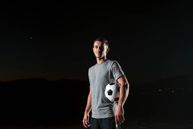 Sokakta futbol topuyla oynayan yakışıklı bir futbolcunun portresi. Yüksek kalite fotoğraf