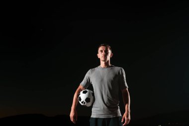 Sokakta futbol topuyla oynayan yakışıklı bir futbolcunun portresi. Yüksek kalite fotoğraf