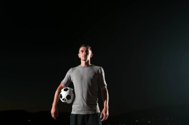 Sokakta futbol topuyla oynayan yakışıklı bir futbolcunun portresi. Yüksek kalite fotoğraf