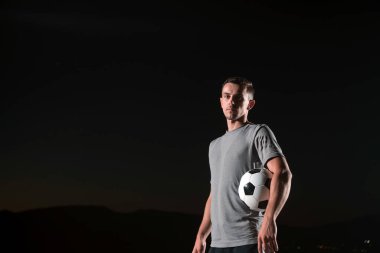 Sokakta futbol topuyla oynayan yakışıklı bir futbolcunun portresi. Yüksek kalite fotoğraf