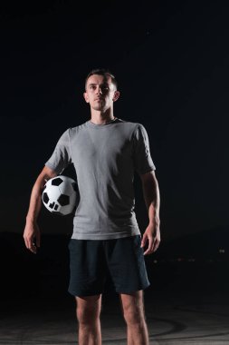 Sokakta futbol topuyla oynayan yakışıklı bir futbolcunun portresi. Yüksek kalite fotoğraf