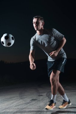 Sokakta futbol topuyla oynayan yakışıklı bir futbolcunun portresi. Yüksek kalite fotoğraf