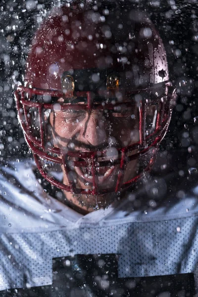 站在球场上的美国足球运动员勇士举着他的头盔准备比赛 准备跑 进攻和得分触地得分的玩家 雨夜与戏剧性镜头耀斑和雨滴 — 图库照片