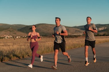 Açık havada koşan üç koşucu. Kentsel alanda antrenman yapan sportif insanlar, sağlıklı yaşam tarzı ve spor kavramları. Yüksek kalite fotoğraf